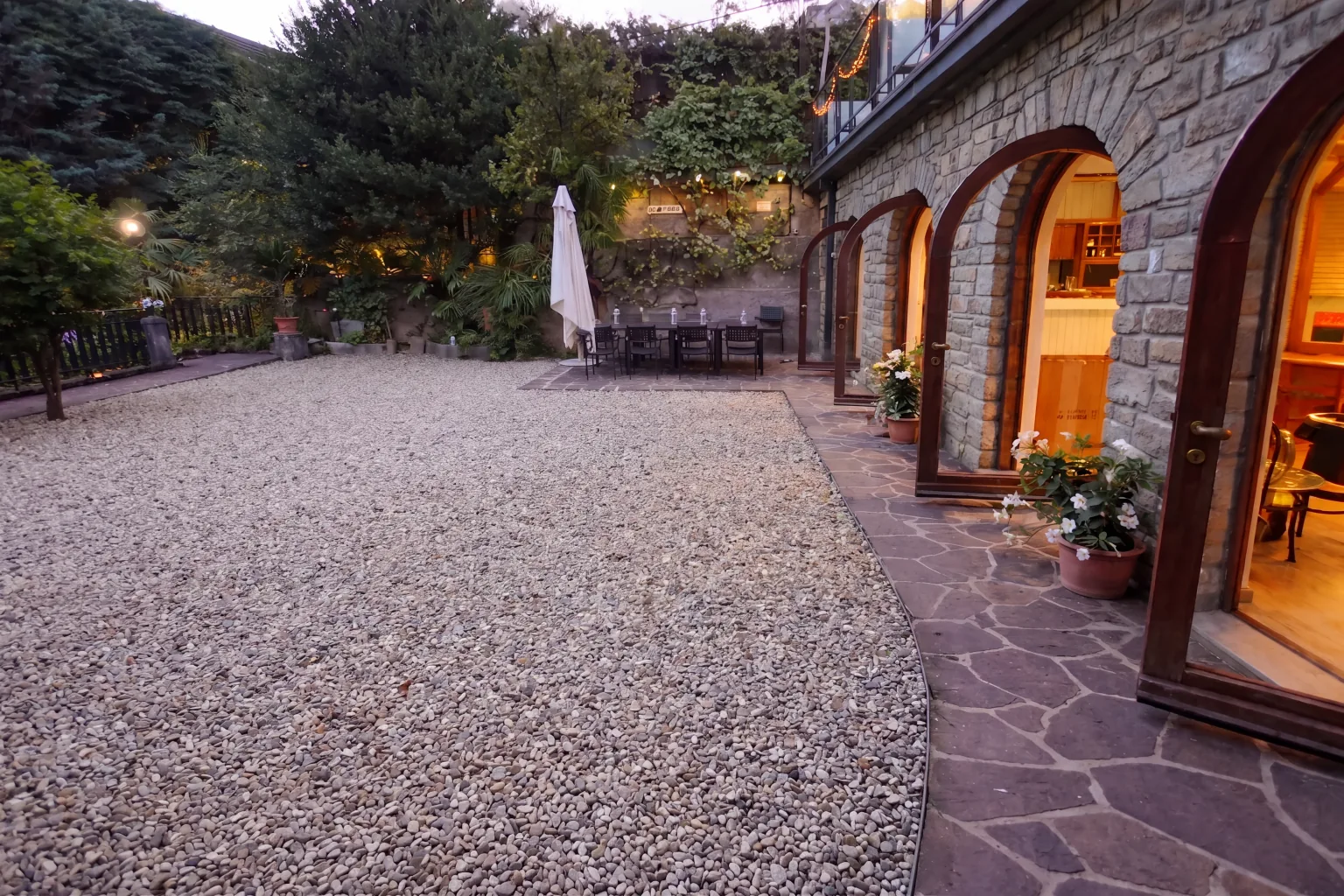 Il giardino in ghiaia e gli archi di Villa Marittimi a Barcola